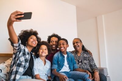 a young woman taking a selfie with her smiling family
