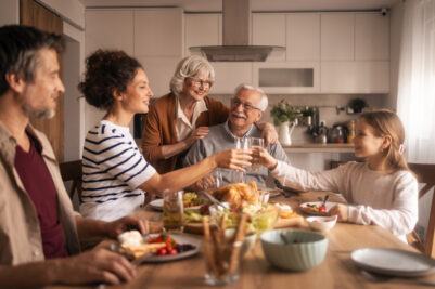 Multi-generational family celebrating holiday meal with toast